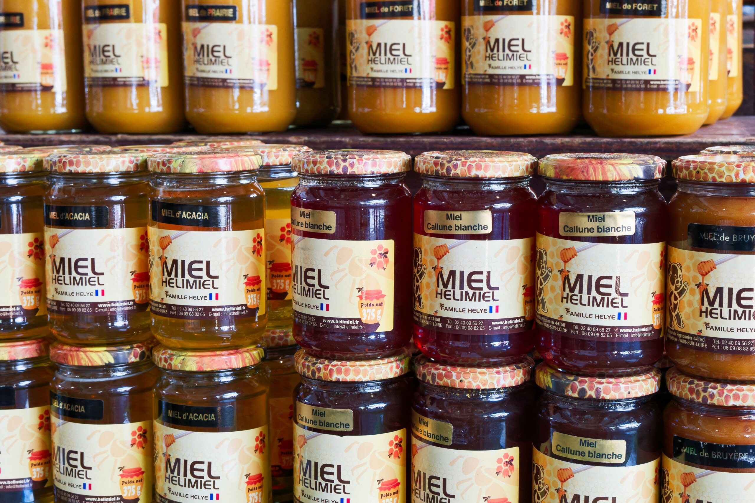 Jars of honey sit on a shelf in a store